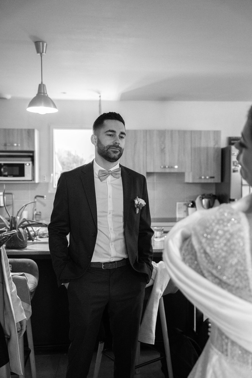 A black and white portrait in a modern kitchen setting on wedding day.