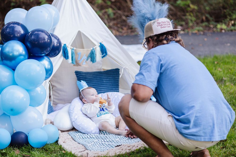 A baby gender reveal party with blue balloons and decorations in an outdoor setting.