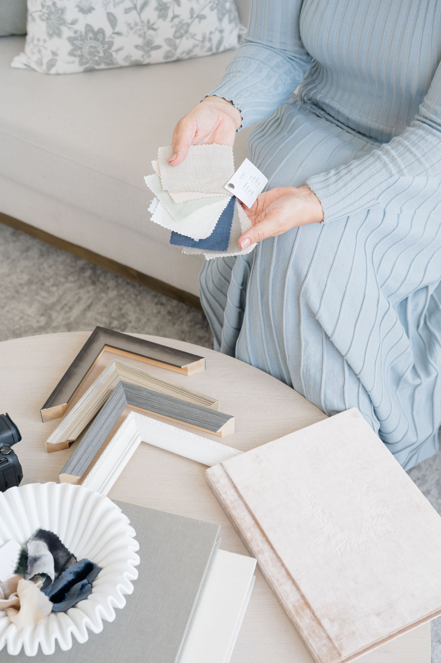 Light blue fabric and photography materials arranged on white surface.