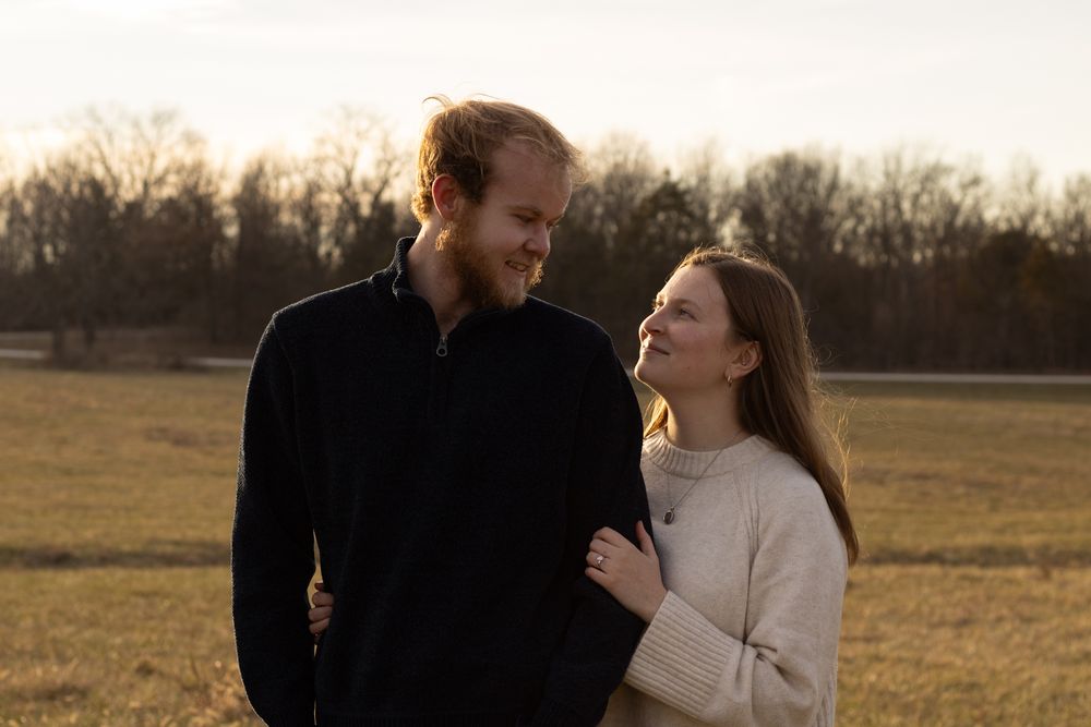 Romantic sunset engagement photo session in an open field.