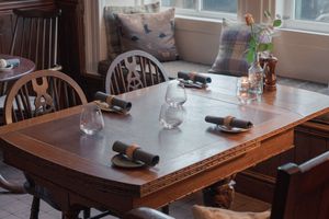 Empty wooden tables and chairs arranged in a casual dining room setting.