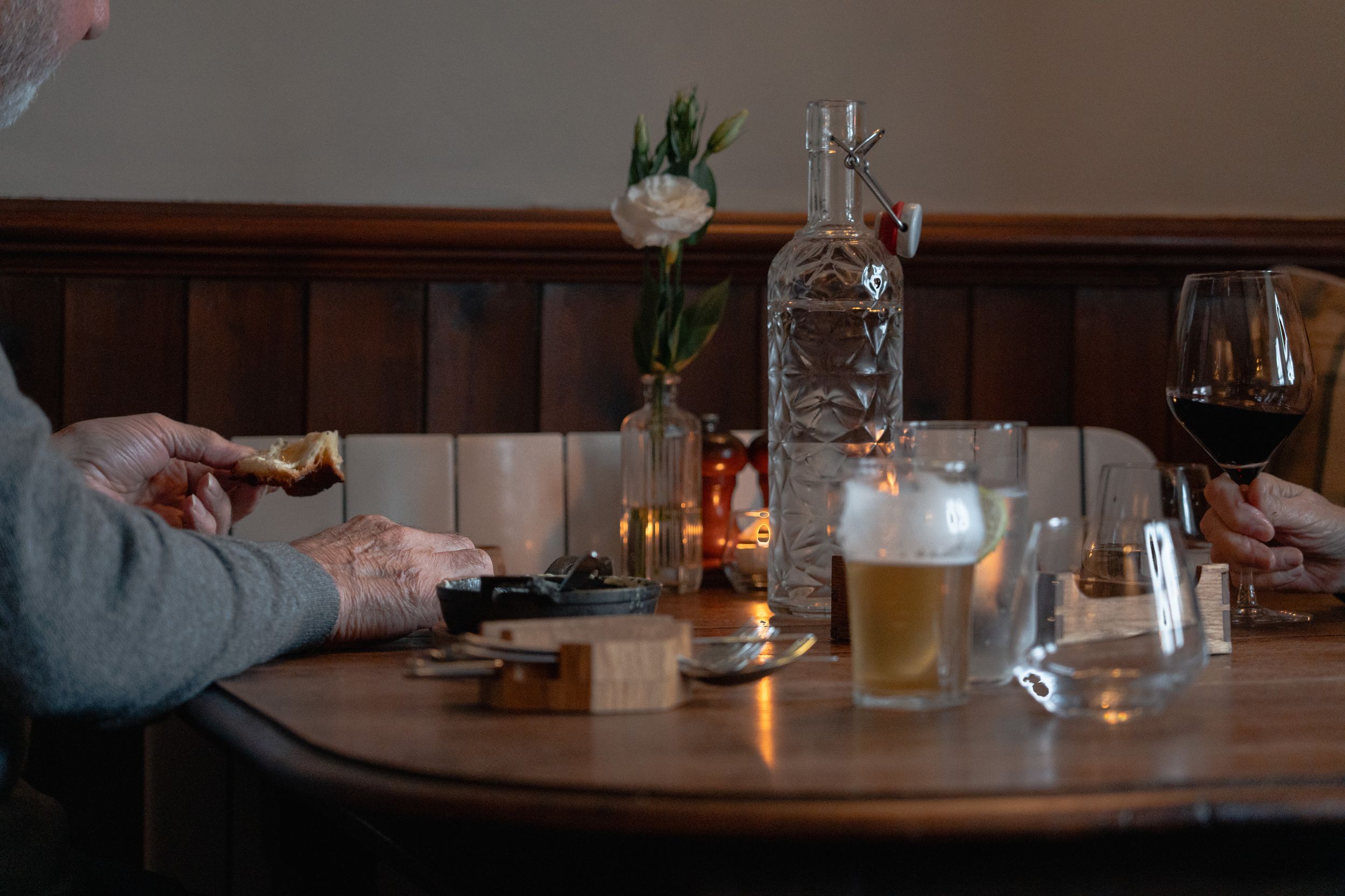 Restaurant table setting with glasses and plates in dim lighting.