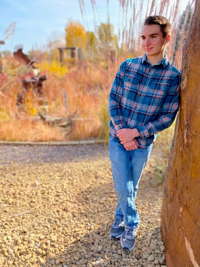 man leaning against a rock wall