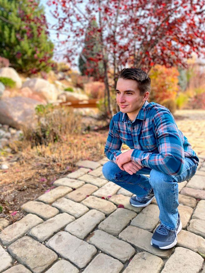 man crouched down on brick walkway