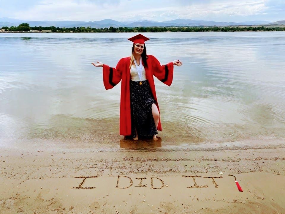 girl posing in cap and gown in the water