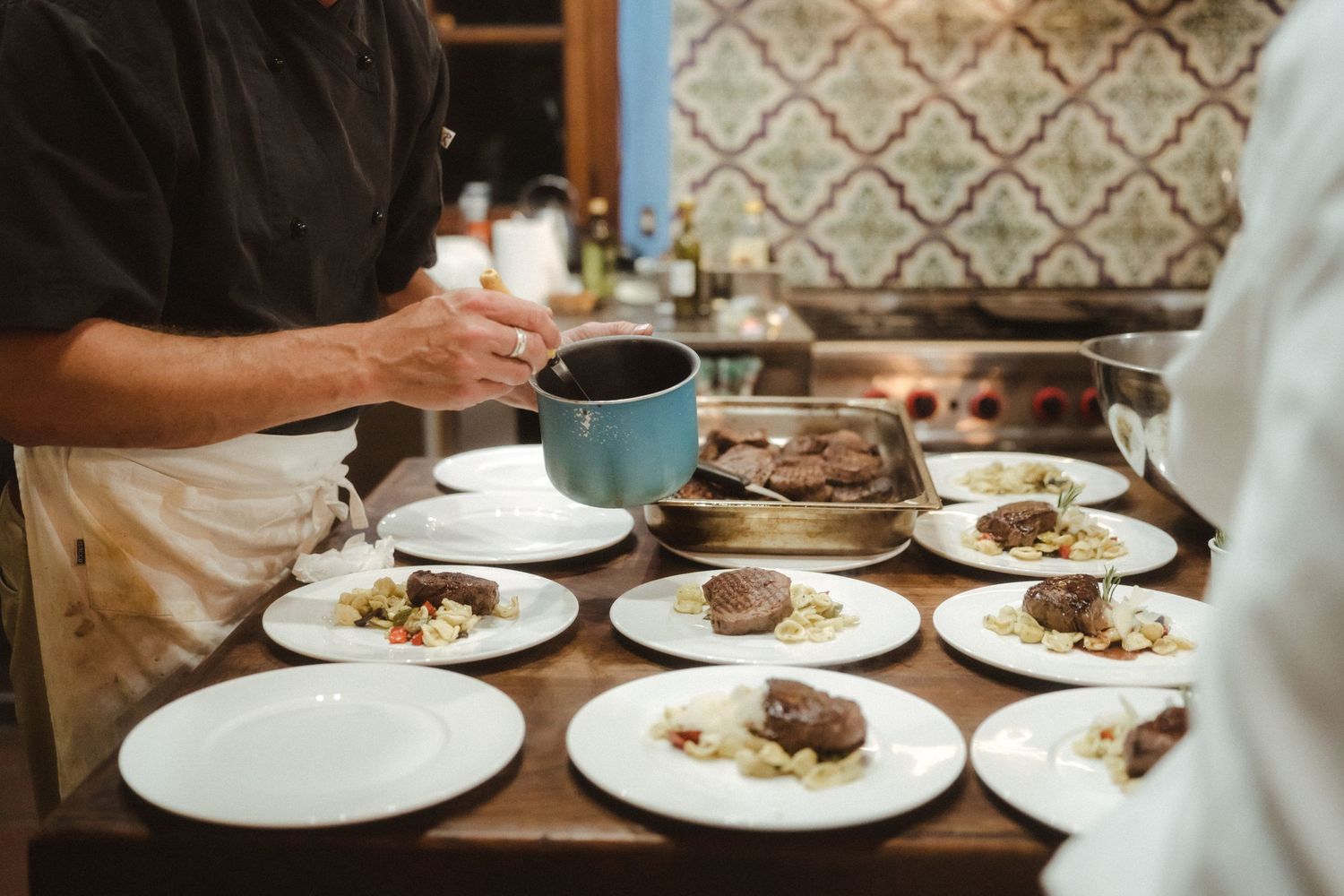 Multiple plates of food being served at an upscale restaurant table.