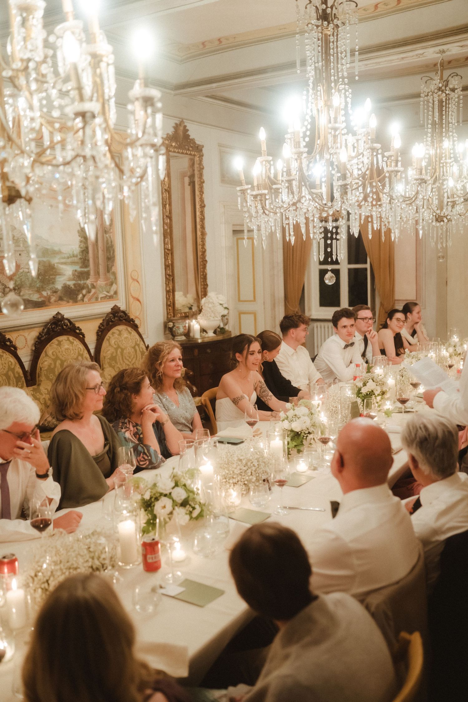 Elegant dining room with crystal chandeliers and long table set for a formal dinner.