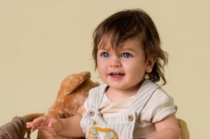 Playful portrait session featuring casual poses and natural interactions against a beige backdrop.