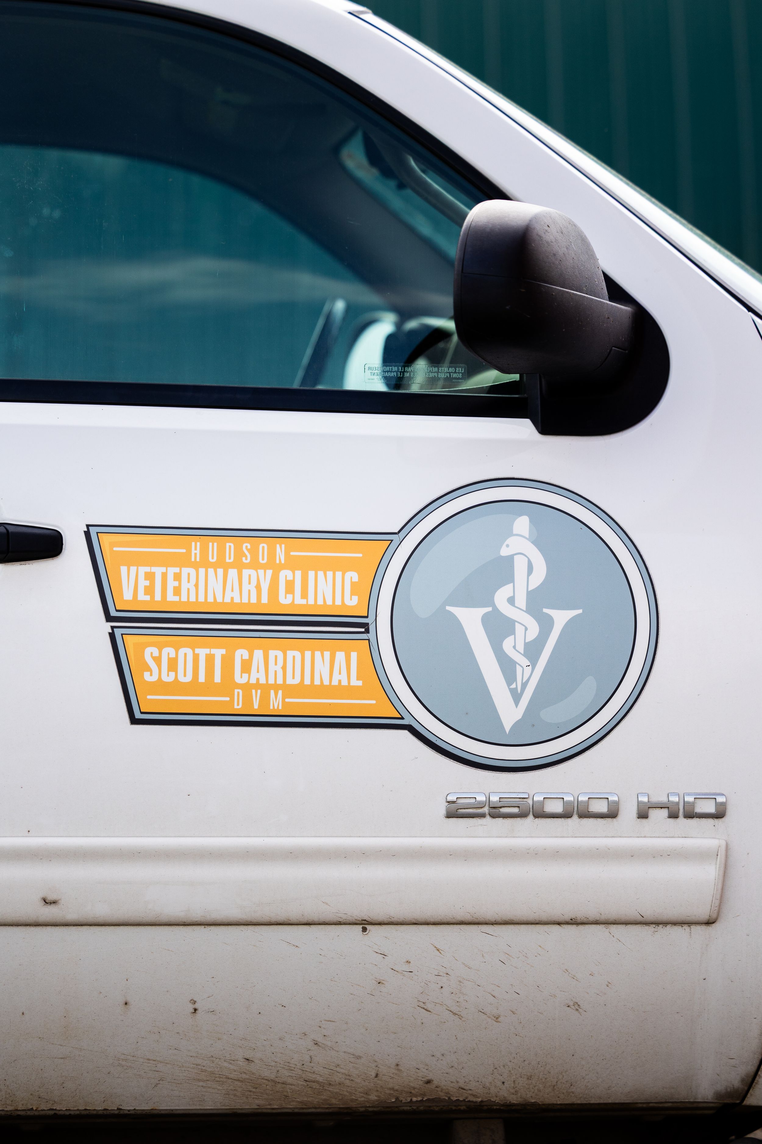 Hudson Veterinary Clinic Scott Cardinal DVM logo on white Chevy 2500HD truck door.