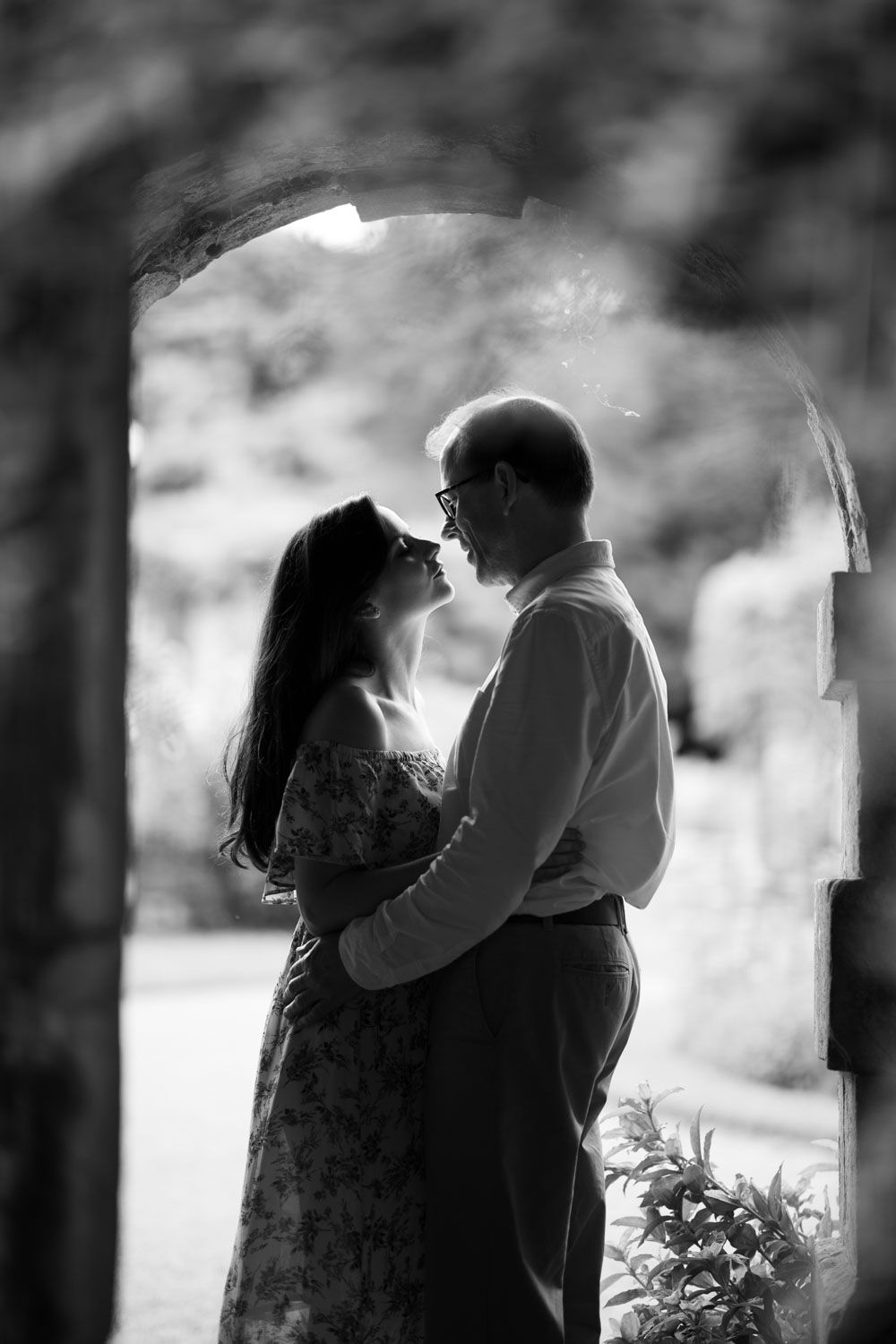 Black and white of couple in archway of historic garden in Kent