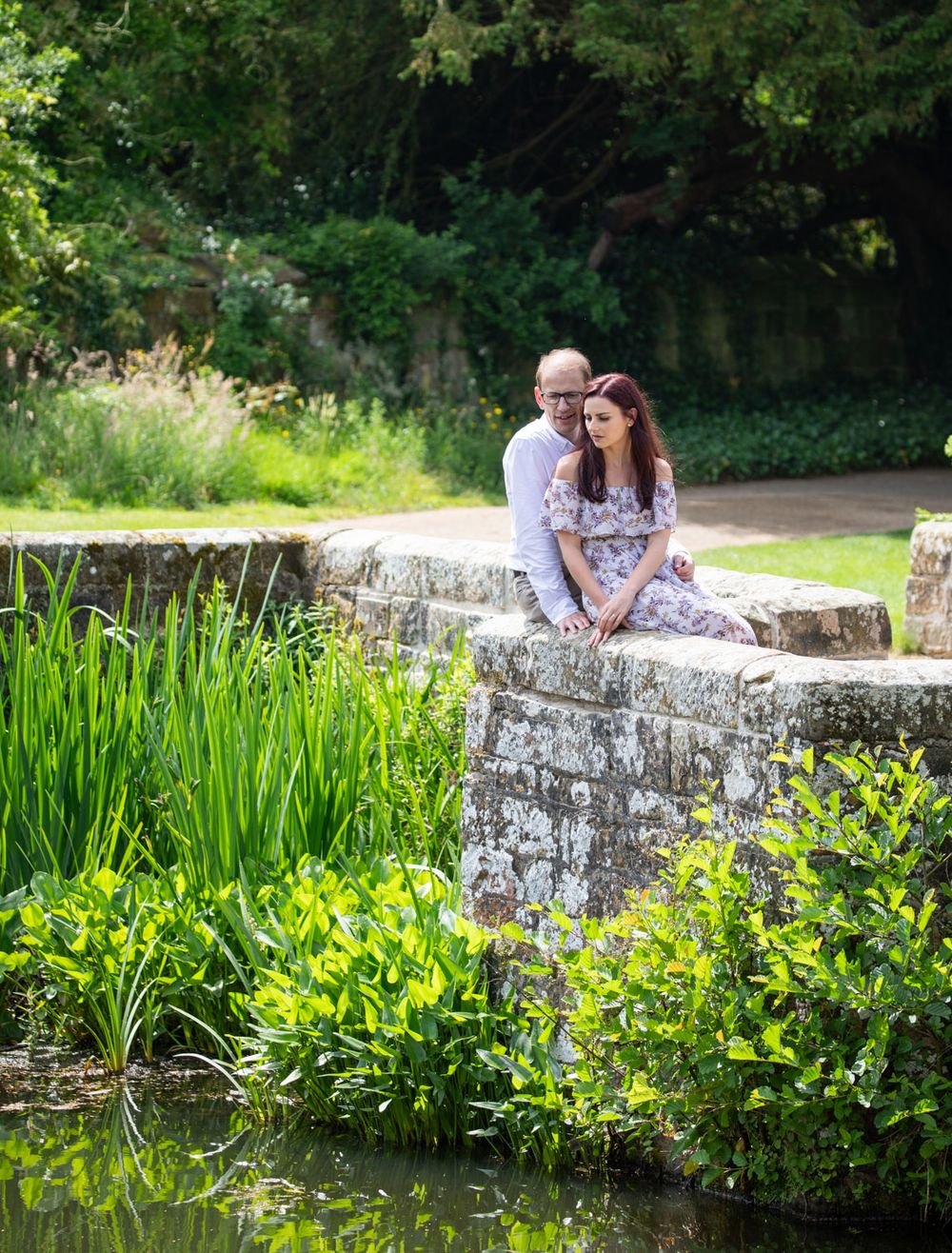 Kent castle moat with couple sitting on garden wall