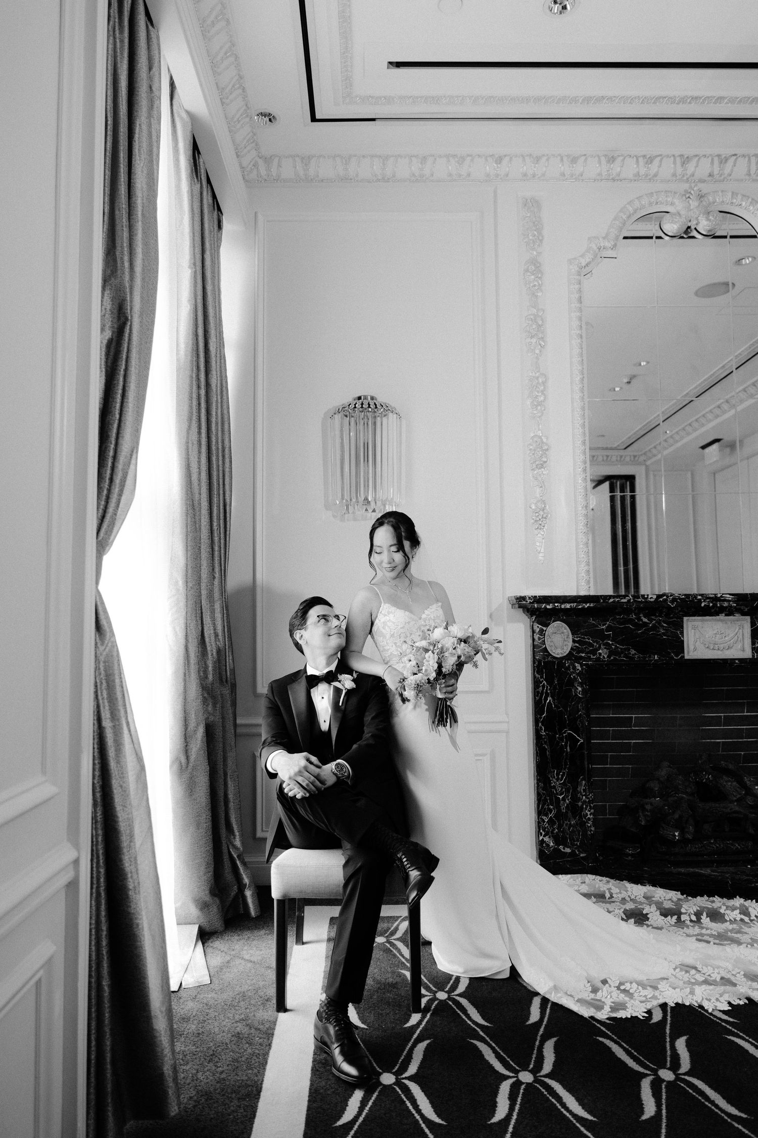 A series of four black and white photographs showing a couple in an elegant room with white walls and ornate details.