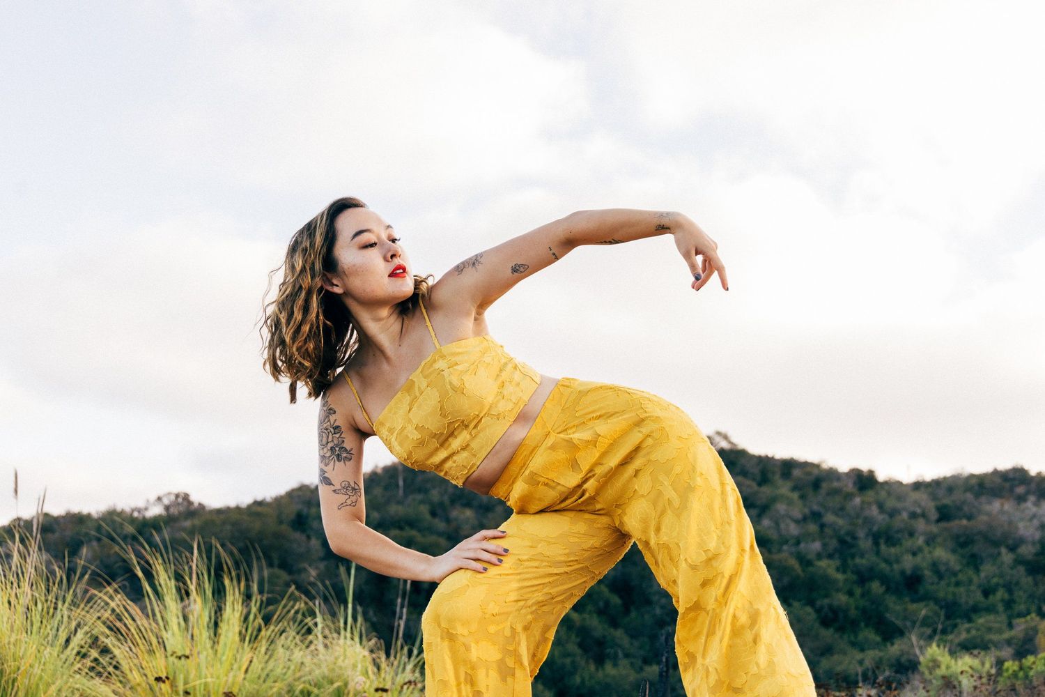 Modern dancer wearing yellow dancing in nature