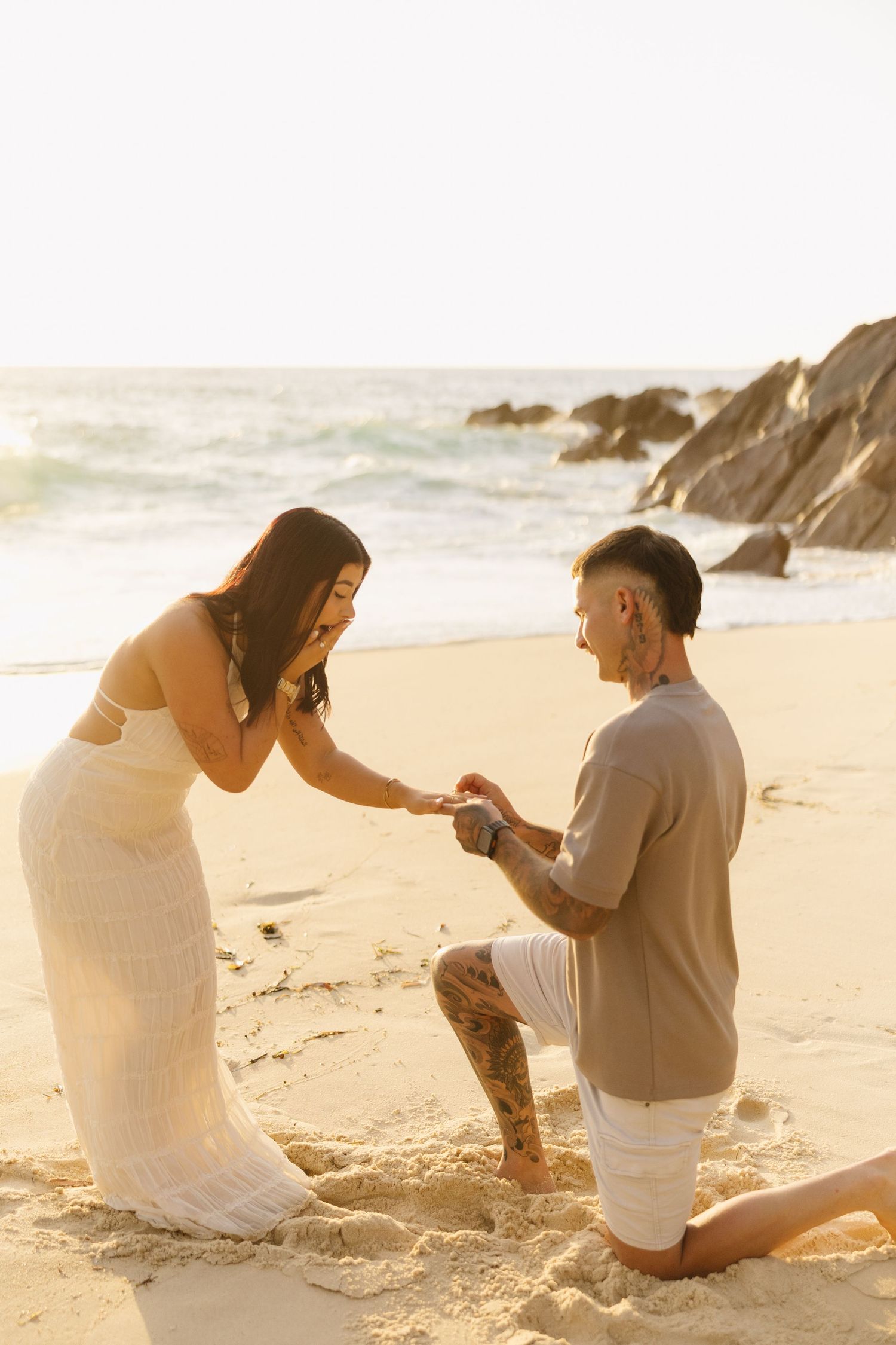 A romantic beach proposal sequence at sunset with couple sitting in the sand by the ocean waves.