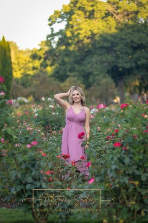 Rose Garden Julia Davis Park Boise Idaho Senior photo girl standing in roses smiling at camera hand in hair