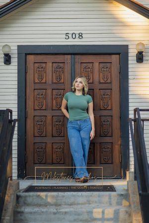 Rose Garden Julia Davis Park Boise Idaho Senior photo girl wearing green t-shirt and jeans standing in front of ornate wooden door