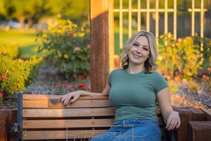 Rose Garden Julia Davis Park Boise Idaho Senior photo girl wearing green t-shirt and jeans sitting park bench