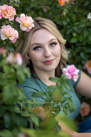 Rose Garden Julia Davis Park Boise Idaho Senior photo girl wearing green t-shirt and jeans with roses surrounding her face