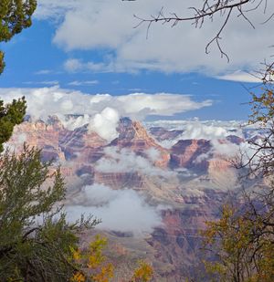 Fine art landscape photograph of Grand Canyon Vishnu temple red rocks dramatic white clouds blue sky western beauty wall art