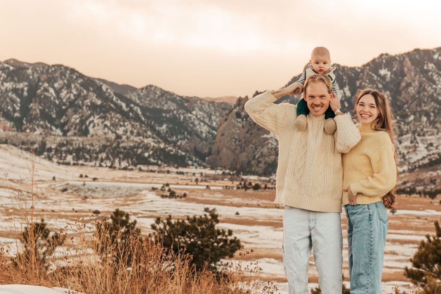 A couple poses together in casual outfits against a scenic mountain backdrop during sunset | Best Family Photo Location with Mountain Views
