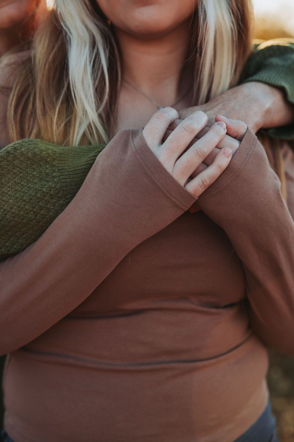 A series of images showing hands making sign language gestures in brown sweater sleeves against a blurred background.