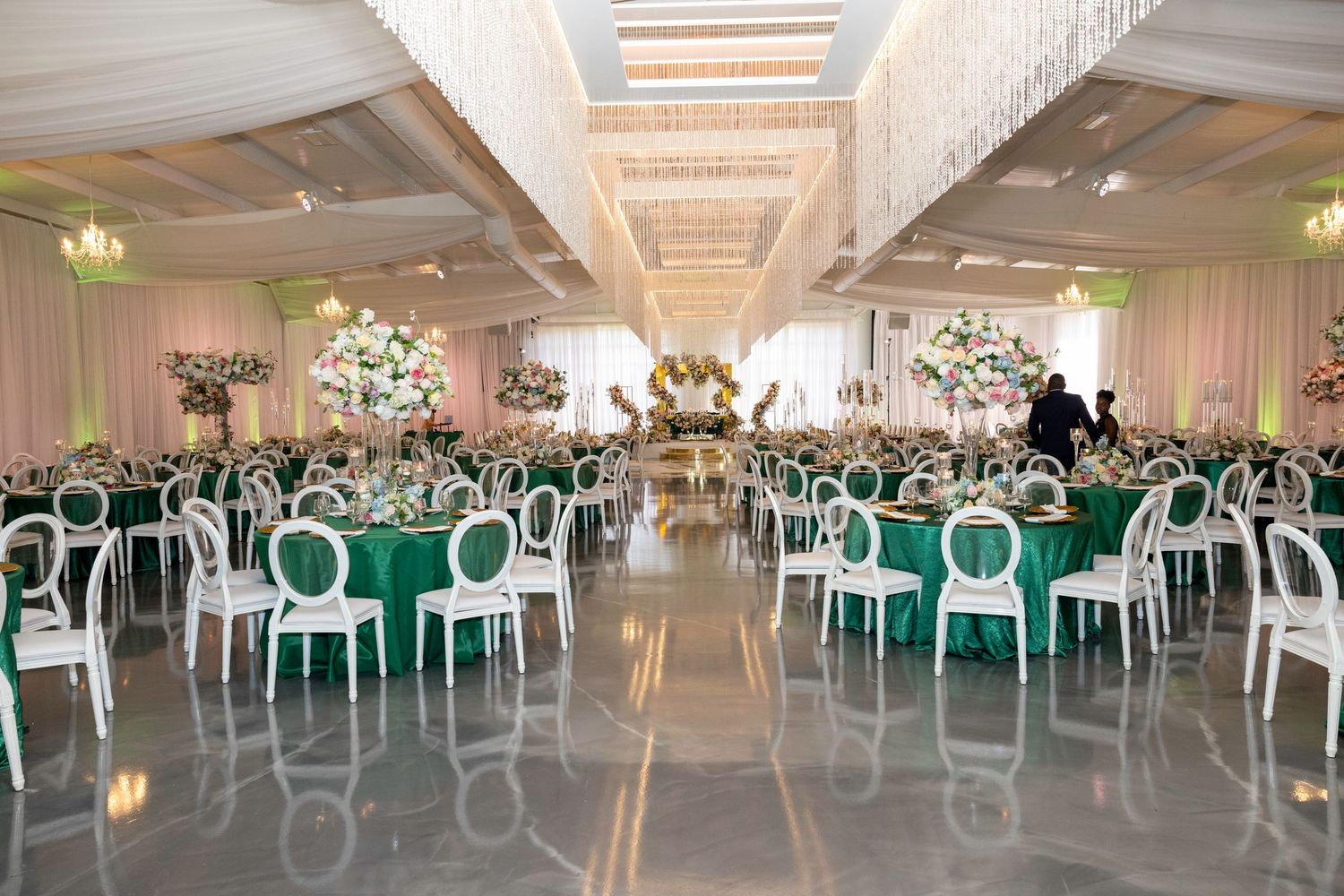 Wedding reception guests dance in formation on the dance floor during a group line dance at an indoor venue.