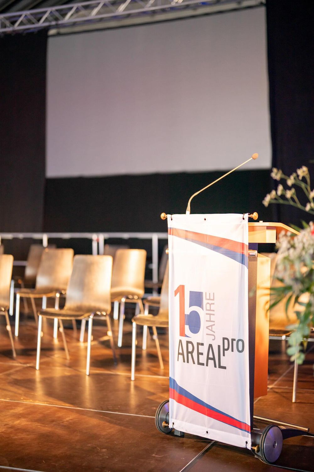 Small white signs mounted on wheels arranged on a wooden stage floor with theatrical lighting.