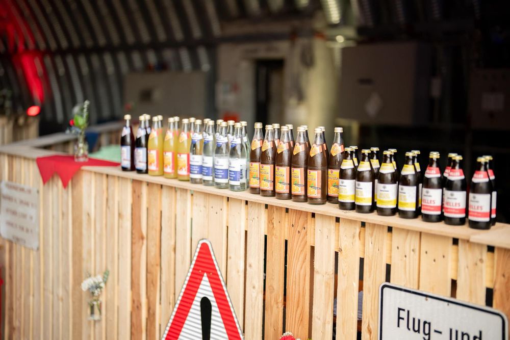Bar shelves stocked with various bottles and glasses under ambient lighting.