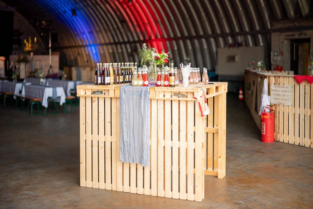 A wooden fence made of vertical slats illuminated by red and blue lights creates a dramatic display at night.