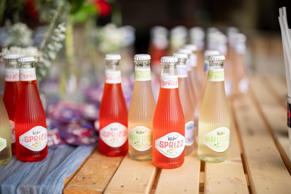 Colorful glass bottles of vintage-style soda lined up on a rustic wooden surface with soft focus background.