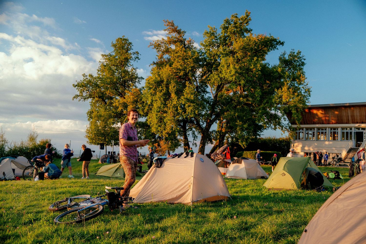 Image typique d'une halte bivouak en bikepacking avec les tentes de tout le monde au coucher du soleil