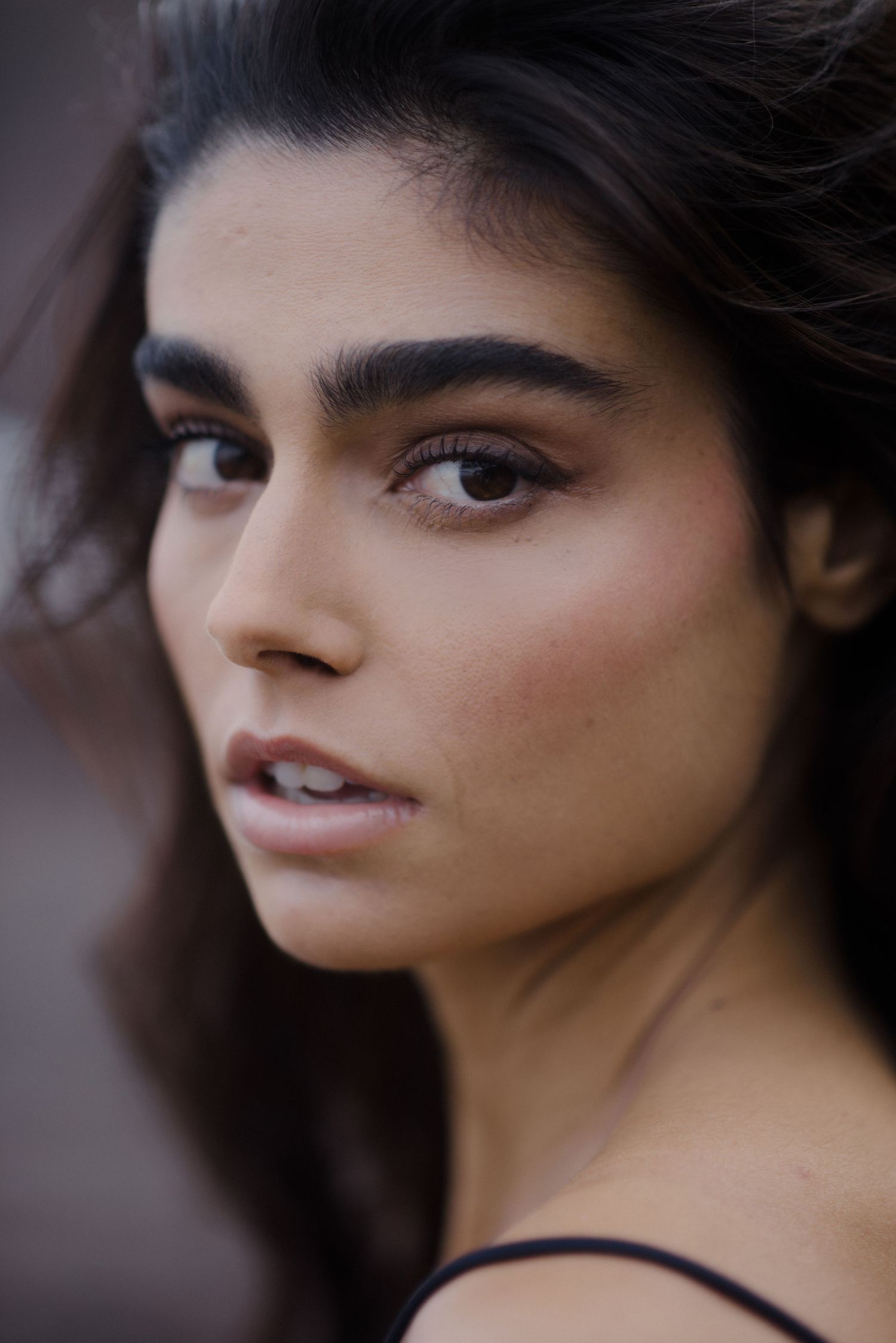 Close-up portrait series showing different angles and expressions with dark hair against a blurred background.
