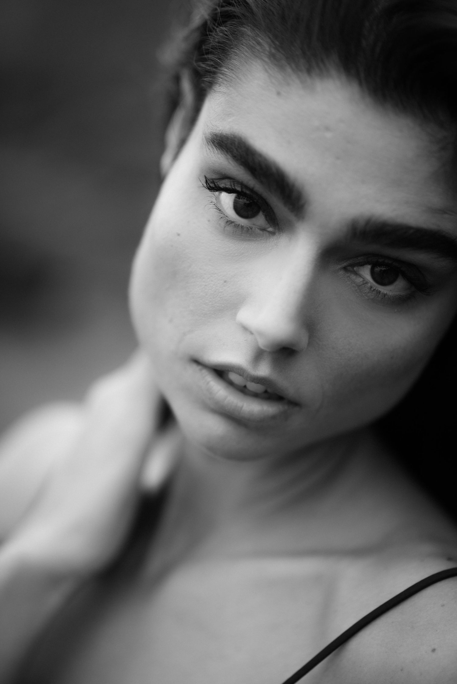 Artistic black and white portrait showing soft focus close-up facial features with dramatic lighting.