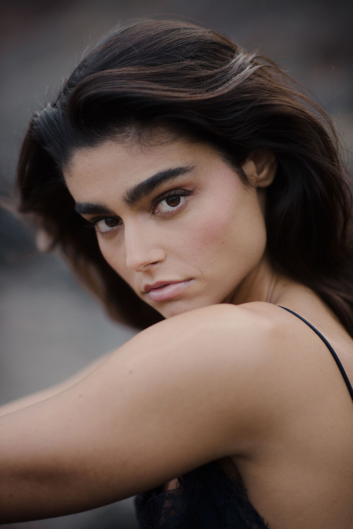 A series of portrait shots showing a person with dark hair in a black top against a blurred background.