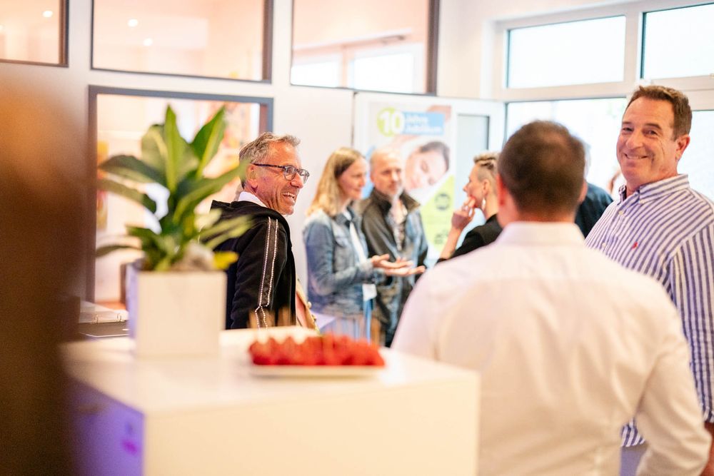 People networking and mingling at a professional business event in a modern office space.
