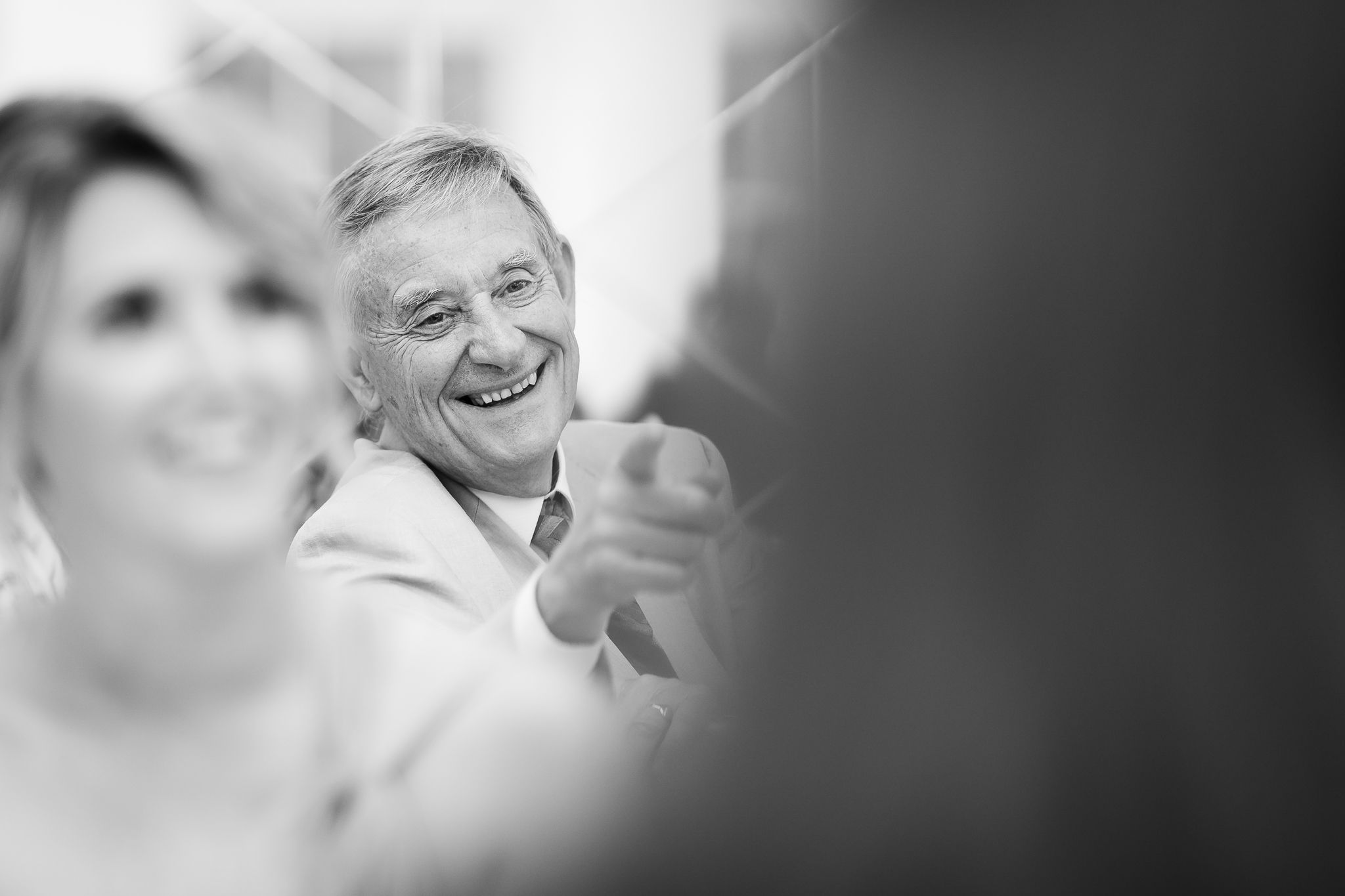 Black and white candid shots of wedding guests laughing during reception speeches. Woodhill Hall.