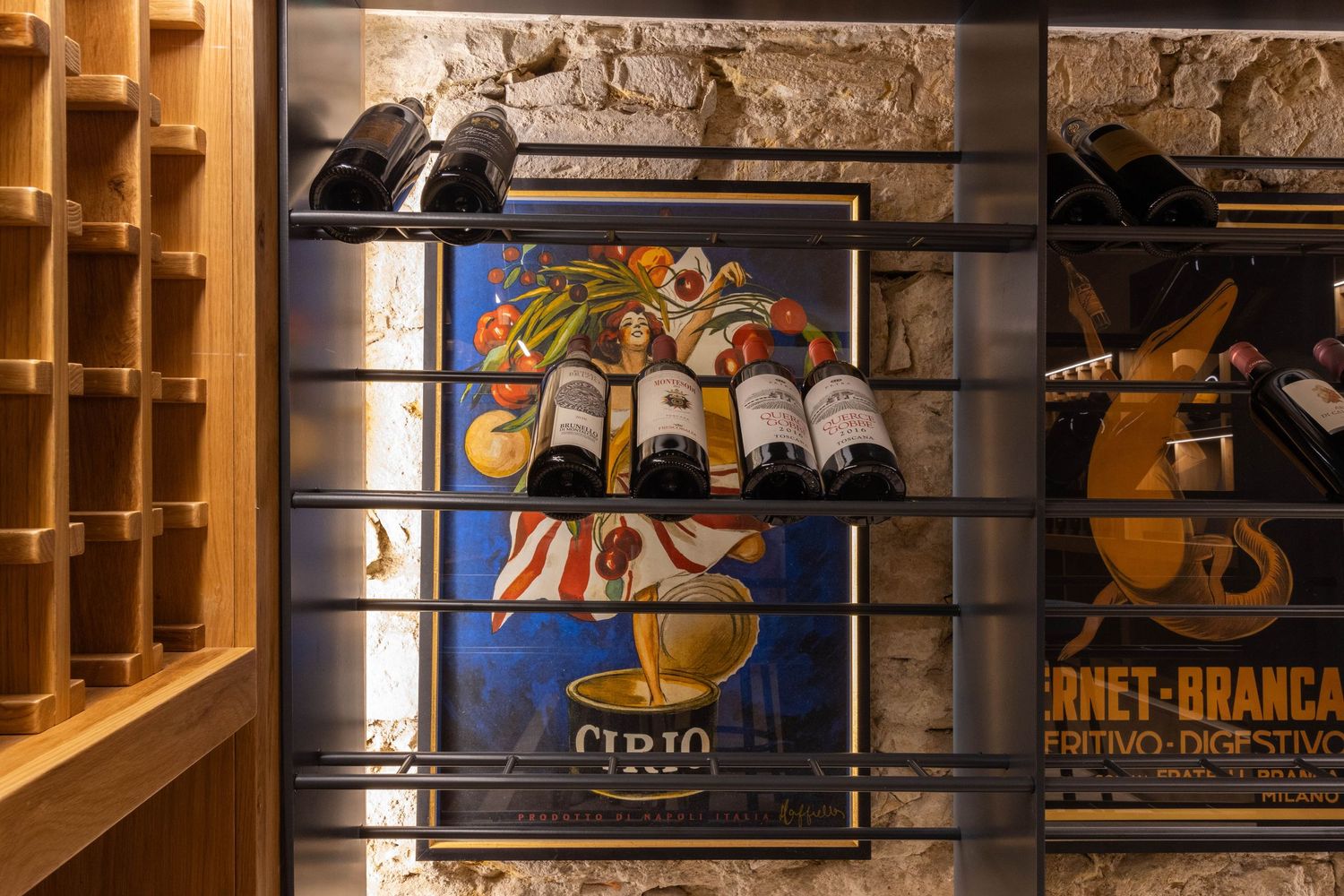 Luxury commercial property photographer in Tuscany, Italy. Vintage art posters and artwork displayed behind a wine rack.