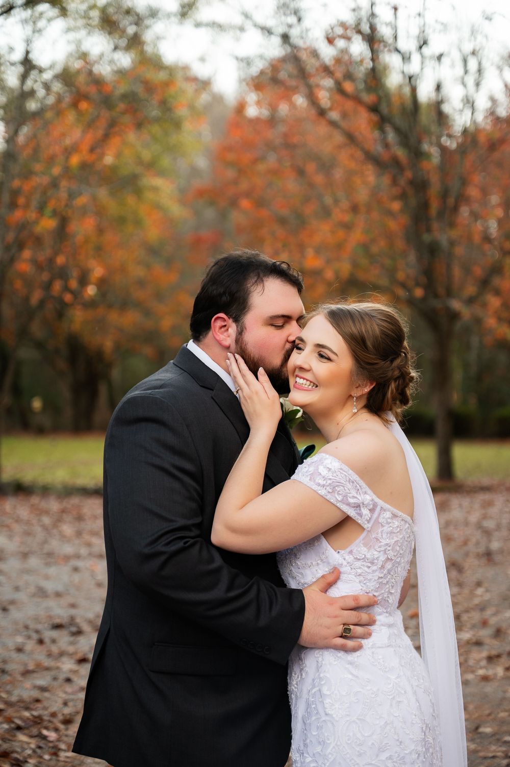 Intimate wedding photography showing tender moments in an autumn outdoor setting.