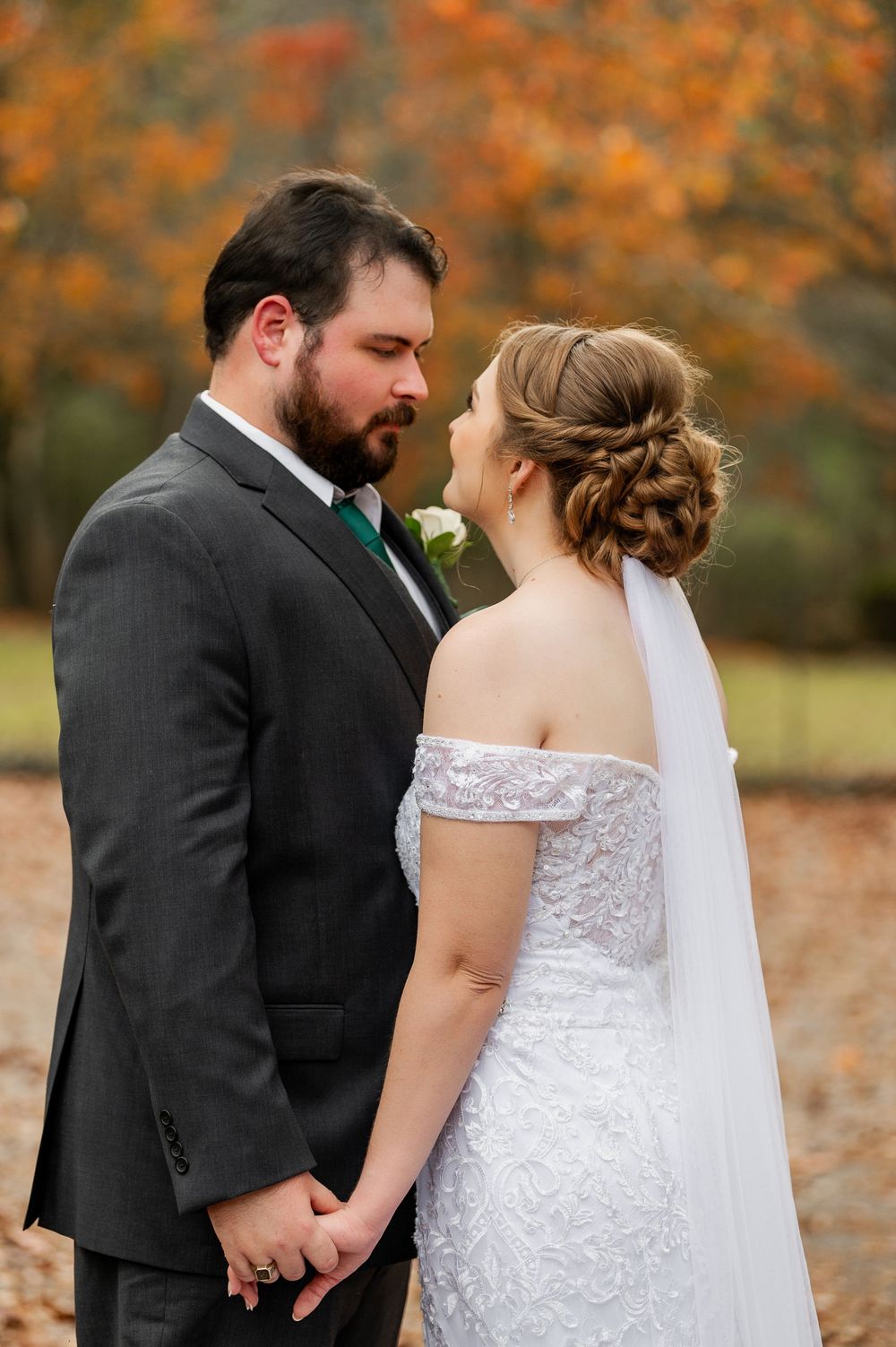 Romantic autumn wedding photos with couple in formal attire among fallen leaves.