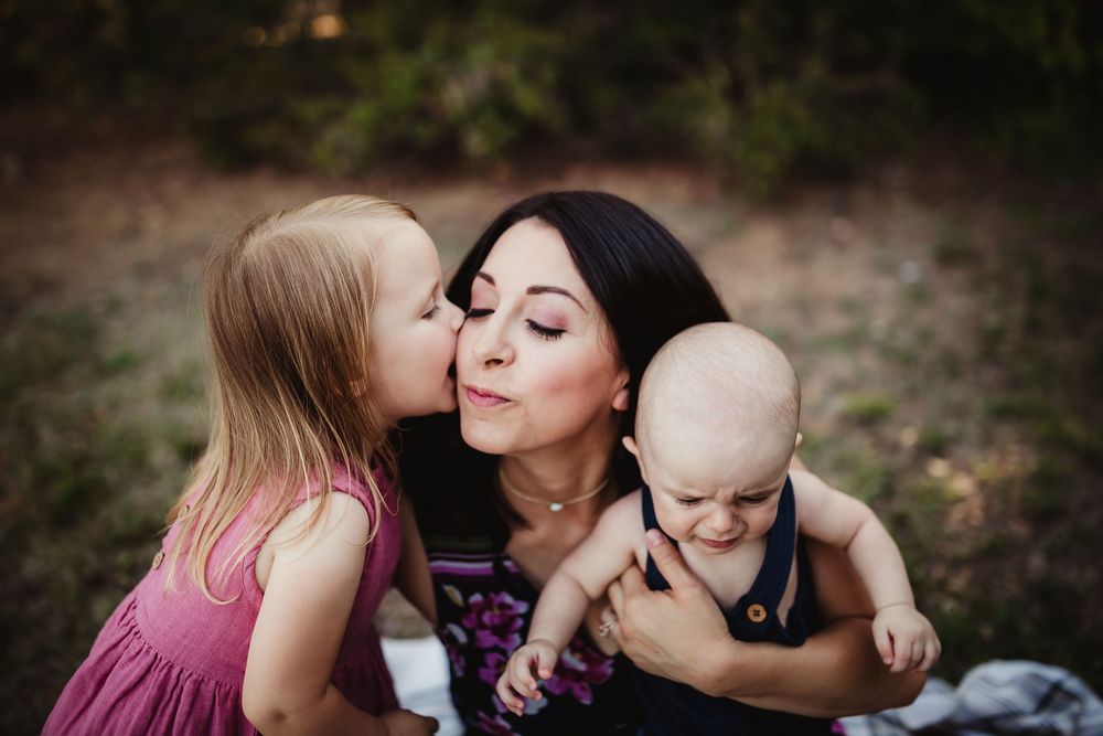 A series of candid family photos showing tender moments of affection and connection outdoors in natural lighting.