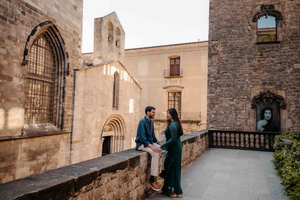 Wide shot of the couple framed by ancient Roman walls