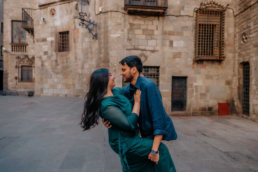 Couple holding hands walking down a narrow cobblestone alley.