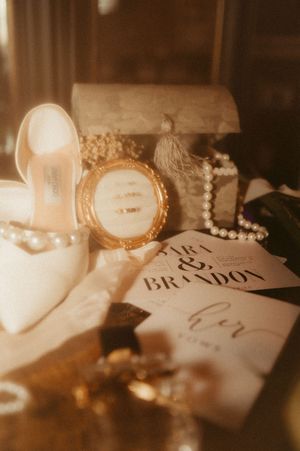 Elegant wedding place settings with handwritten name cards and pearl necklaces in warm sepia tones.