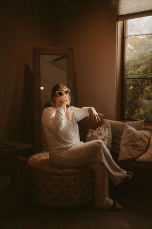Moody boudoir photography session in a sunlit room with vintage furniture.