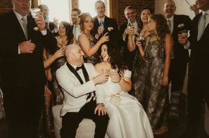 Guests in formal attire dance and mingle during an elegant indoor wedding reception celebration.