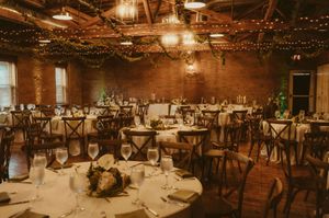 Rustic wedding reception venue with exposed brick walls and twinkling string lights creating a romantic atmosphere.