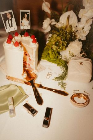 Wedding details including makeup, jewelry, and Chanel accessories arranged on white surface.