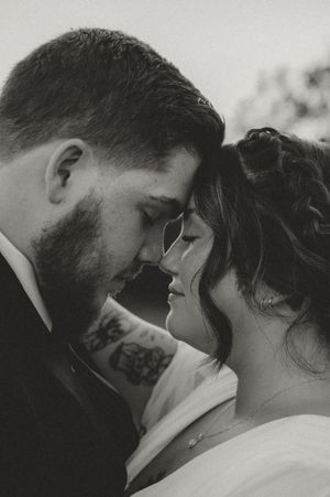 An intimate black and white close-up portrait of newlyweds sharing a tender moment.
