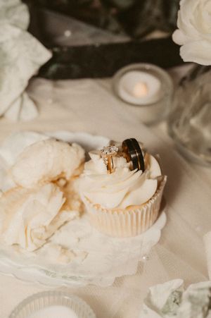 White dessert plates and cupcake wrappers arranged on an elegant table setting.