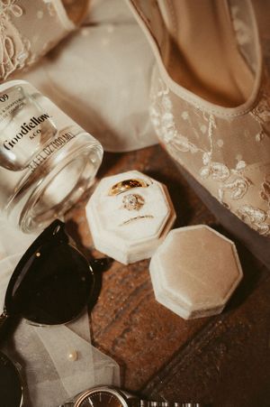 Wedding detail shot of champagne bottles and lace decorations on rustic surface.